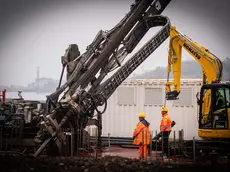 Grandi macchinari all’opera nell’area ex Aquila nel cantiere Pnrr per realizzare la banchina