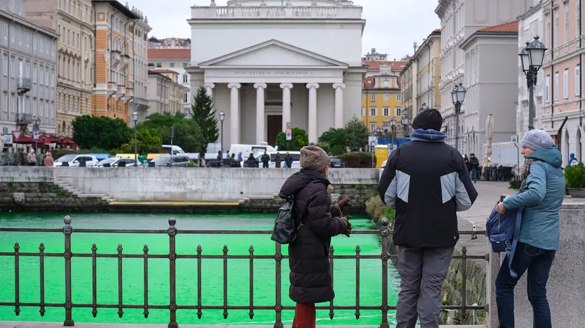I passanti in Ponterosso osservano stupiti il mare del Canal Grande colorato di verde Foto Silvano e Bruni