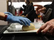 Persone in fila in una mensa Caritas per un pasto caldo