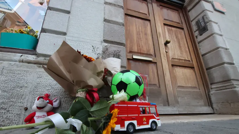 Tra gli omaggi davanti al palazzo dell’omicidio anche una camionetta giocattolo dei pompieri. Foto Lasorte
