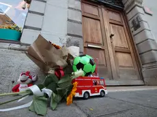 Tra gli omaggi davanti al palazzo dell’omicidio anche una camionetta giocattolo dei pompieri. Foto Lasorte