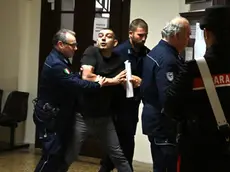 Hasan Uzun portato in Tribunale dalle guardie carcerarie (Bruni)