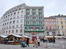 Il palazzo liberty di piazza della Borsa dell’architetto Max Fabiani con striscioni e bandiere Foto Silvano