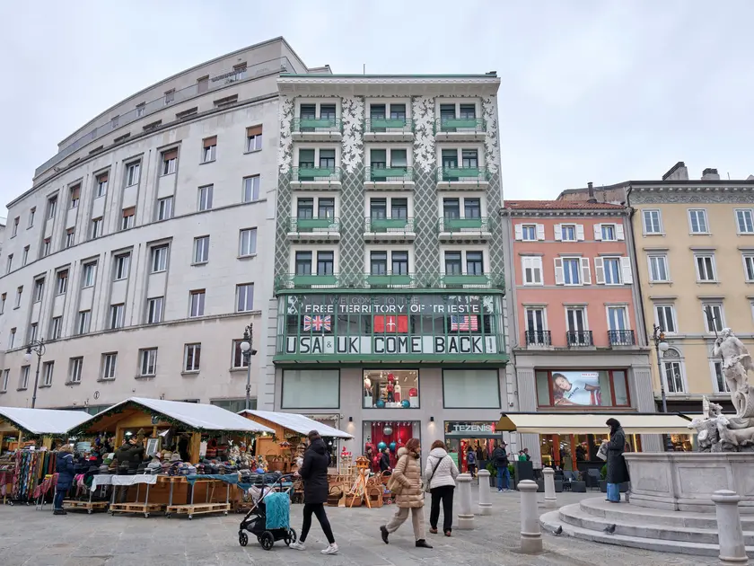 Il palazzo liberty di piazza della Borsa dell’architetto Max Fabiani con striscioni e bandiere Foto Silvano