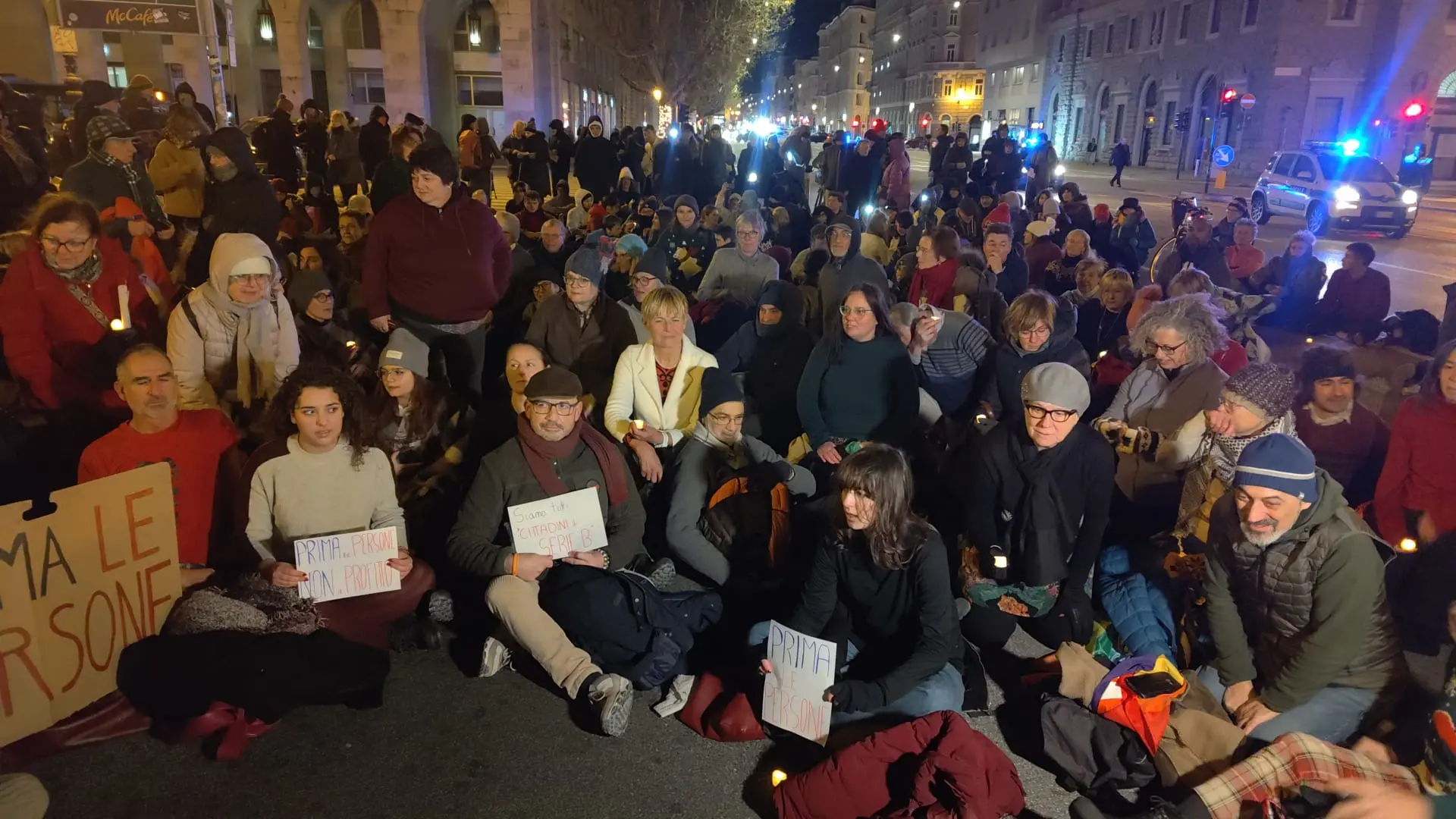 Alcune persone si sono sedute per terra e tolte le giacche "per capire il freddo che provano i migranti. Stiamo un minuto così per renderci conto"