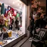 Clienti davanti a una vetrina in centro, sullo sfondo le luminarie di Natale (Bonaventura)