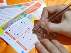 Una giocatrice compila una schedina del Superenalotto, in una immagine di archivio