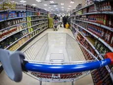 Un carrello della spesa lungo la corsia di un supermercato. Foto Ansa