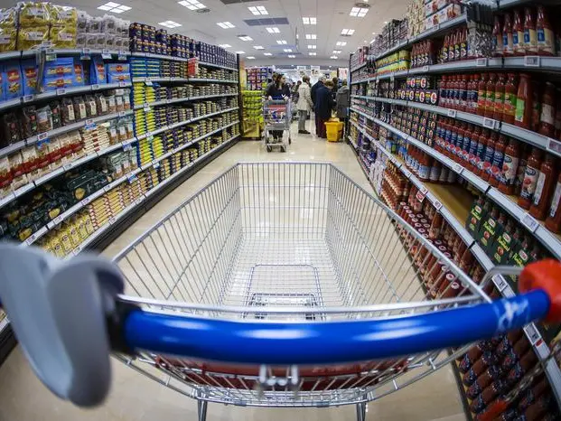 Un carrello della spesa lungo la corsia di un supermercato. Foto Ansa