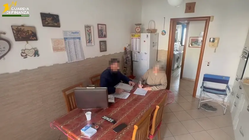 La firma di un contratto da parte di un'anziana nelle immagini diffuse dalla Finanza