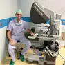 Paolo Umari in sala operatoria accanto a un robot chirurgico