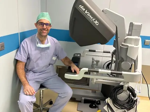 Paolo Umari in sala operatoria accanto a un robot chirurgico