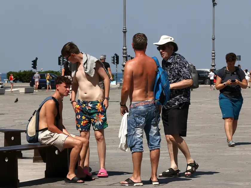 Turisti a petto nudo in centro a Trieste (foto Lasorte)