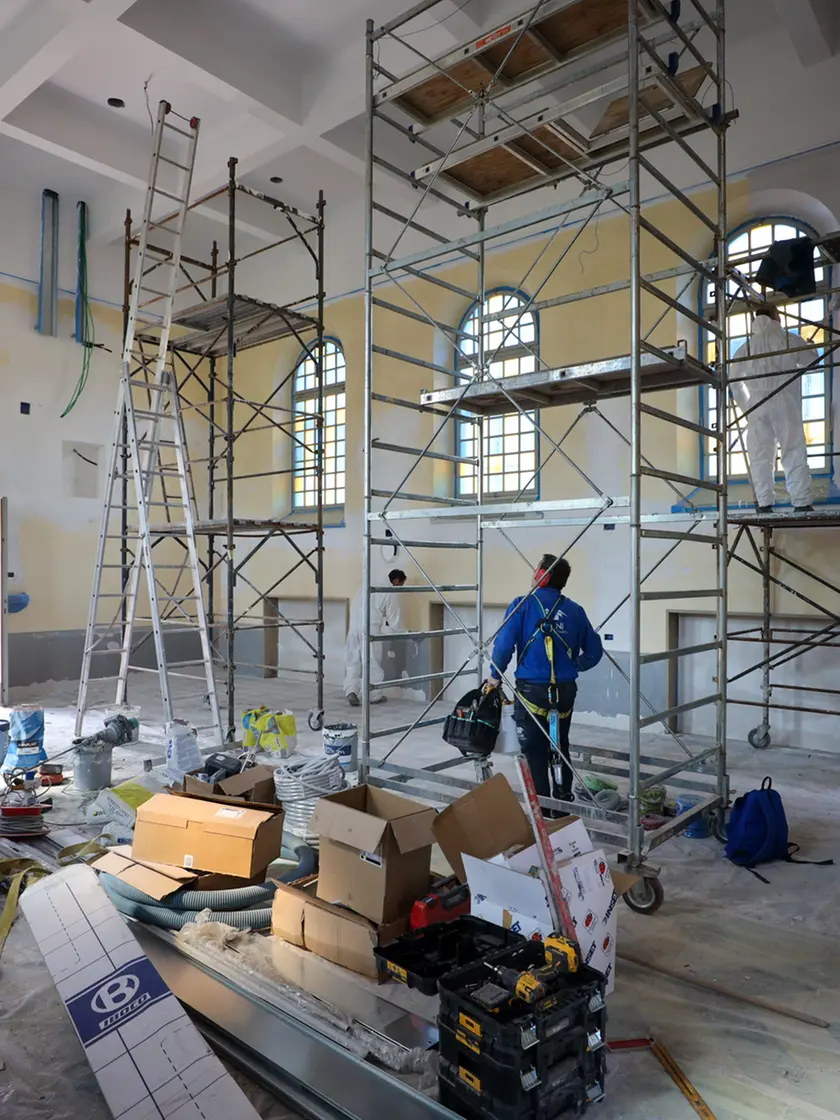 Lavori in corso nella chiesa delle Stimmate all’interno del parco Basaglia che cambia destinazione: da luogo di culto a piccolo teatro con palco, soppalco, una bussola e 99 posti a sedere. Gli operai stanno completando l’intervento di ristrutturazione all’interno mentre, all’esterno, sono visibili i ponteggi per completare la risistemazione della facciata. Foto Tibaldi
