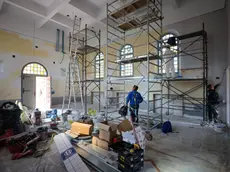 Lavori in corso nella chiesa delle Stimmate all’interno del parco Basaglia che cambia destinazione: da luogo di culto a piccolo teatro con palco, soppalco, una bussola e 99 posti a sedere. Gli operai stanno completando l’intervento di ristrutturazione all’interno mentre, all’esterno, sono visibili i ponteggi per completare la risistemazione della facciata. Foto Tibaldi