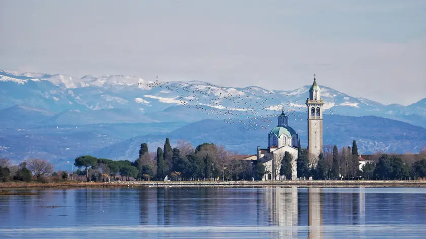 Una suggestiva panoramica dell’isola-santuario di Barbana in una foto di Enrico Cester
