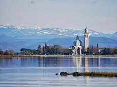 Una suggestiva panoramica dell’isola-santuario di Barbana in una foto di Enrico Cester