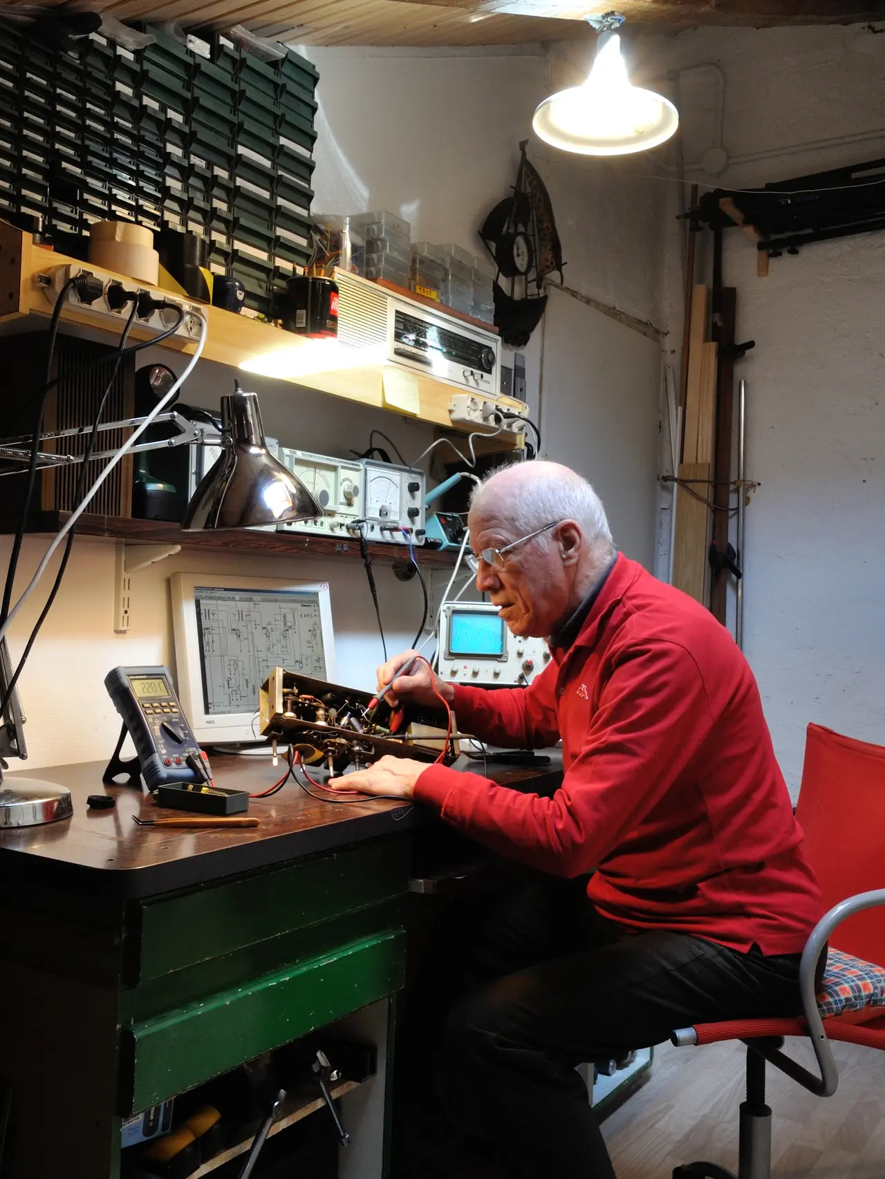 Paolo Fachin al lavoro mentre sistema un vecchio apparecchio radiofonico