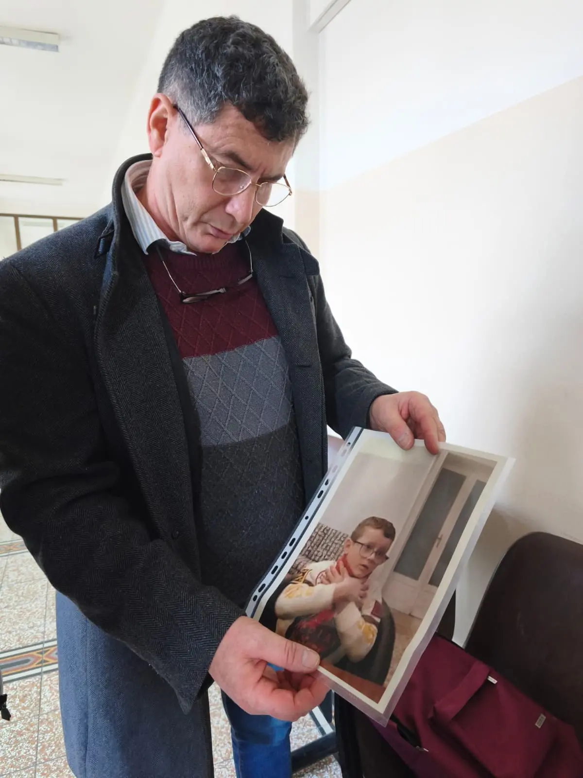 Paolo Trame con la foto del figlio in tribunale