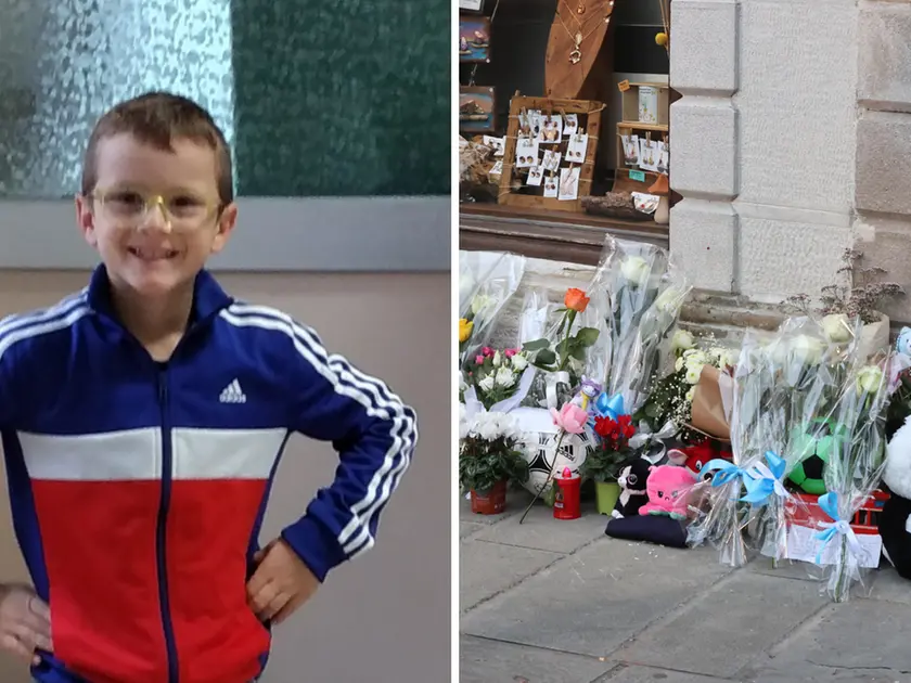 Il piccolo Giovanni Trame e i fiori e peluche lasciati all’esterno dello stabile di piazza Marconi 3 a Muggia, teatro del delitto (Lasorte)