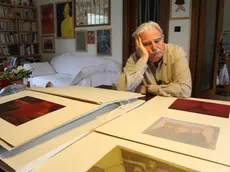 Ugo Pierri nella sua casa triestina: davanti a lui un tavolo zeppo di dipinti