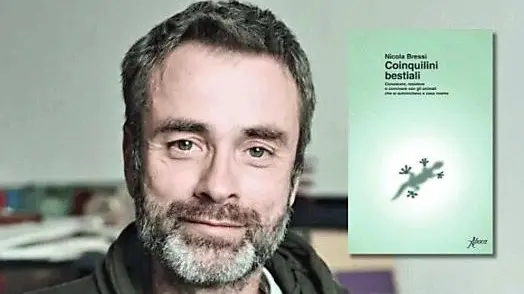 Nicola Bressi con la copertina del suo libro Coinquilini bestiali