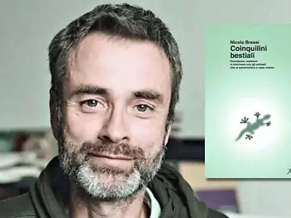 Nicola Bressi con la copertina del suo libro Coinquilini bestiali