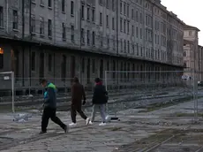 Alcuni migranti nell’area di Porto Vecchio, i cui magazzini dismessi diventano spesso luoghi di bivacco foto Lasorte
