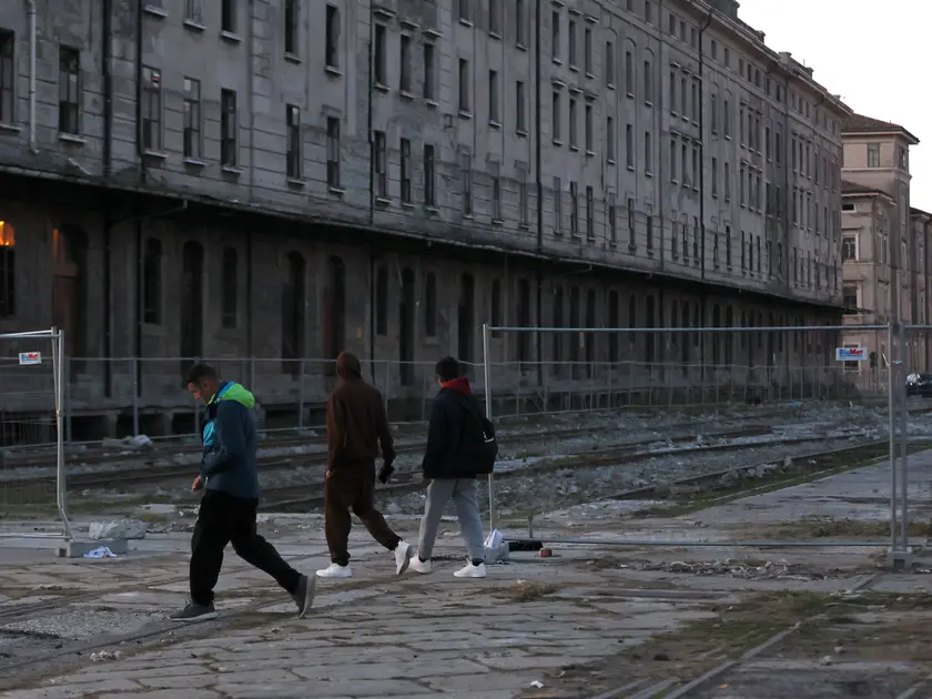 Alcuni migranti nell’area di Porto Vecchio, i cui magazzini dismessi diventano spesso luoghi di bivacco foto Lasorte