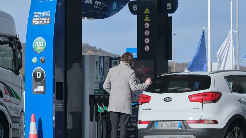 Un automobilista fa rifornimento in Slovenia: oggi scattano i nuovi aumenti oltreconfine (foto Silvano)