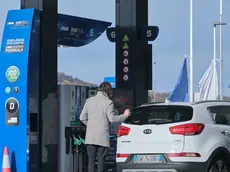 Un automobilista fa rifornimento in Slovenia: oggi scattano i nuovi aumenti oltreconfine (foto Silvano)