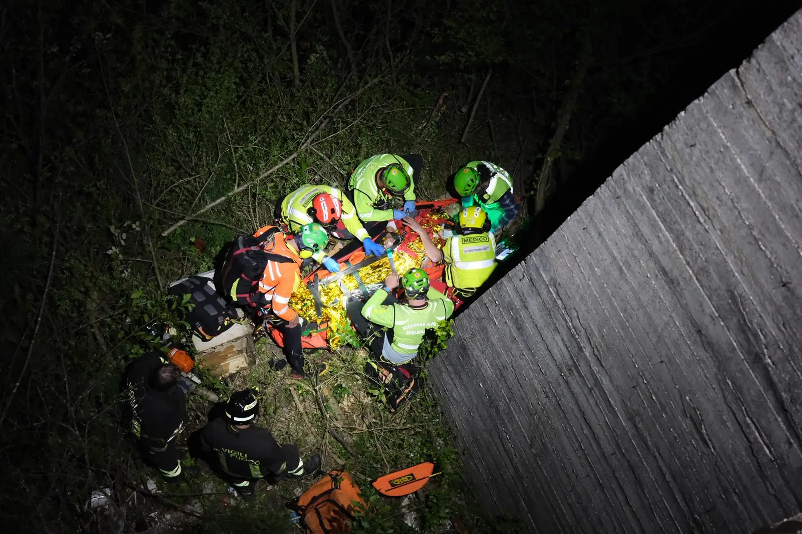 Parcheggia la moto a lato strada, con l’intenzione di ammirare il panorama del golfo di Trieste, ma qualcosa va storto: cade dal muretto, forse nel tentativo di scattare una foto, e precipita per diversi metri nella boscaglia sottostante. Sul posto sono intervenuti un’ambulanza e un'automedica del 118, i vigili del fuoco, il personale della polizia locale e il Soccorso alpino, vista la complessità delle operazioni per recuperare il ferito. Ecco le immagini del difficile recupero (Foto Silvano)