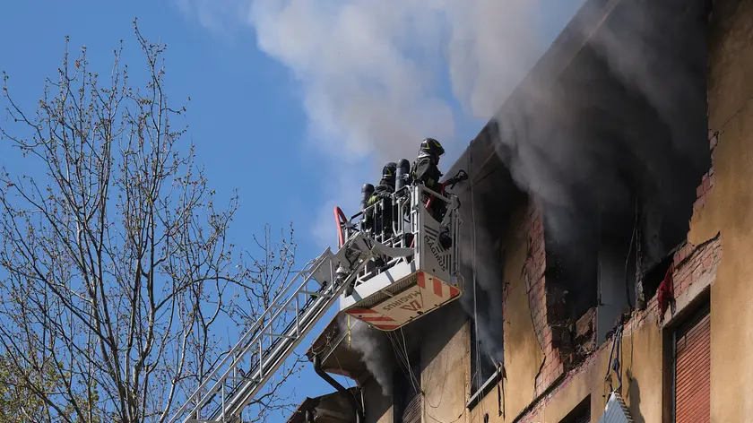 I pompieri mentre spengono il fuoco nella casa esplosa in via Baiamonti (Silvano)
