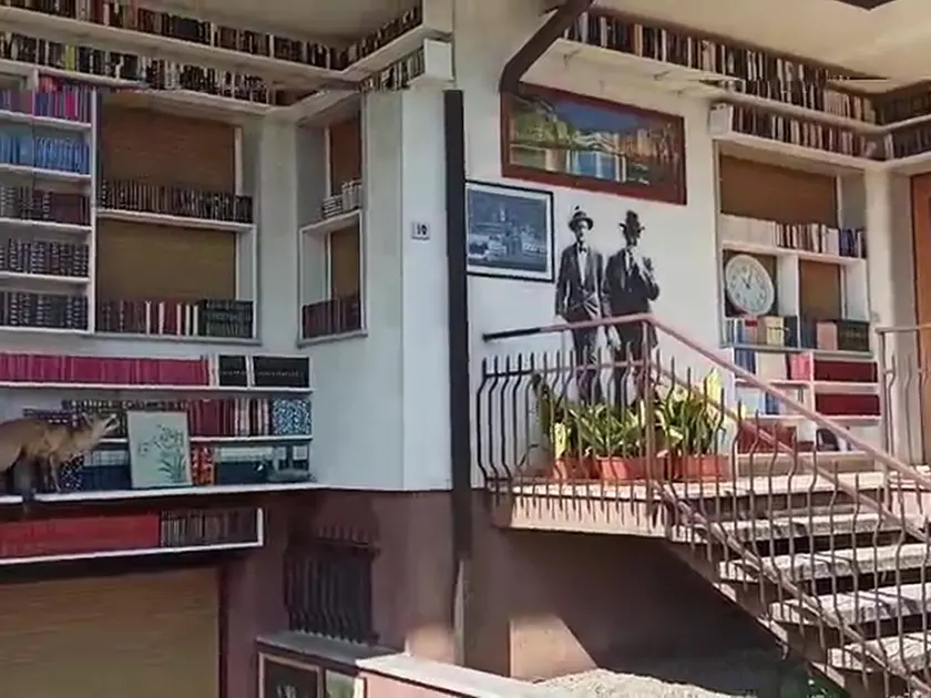 La facciata della casa di Walter Agosti, 80 anni, interamente rivestita di scaffali