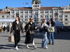 Tre turiste si godono una passeggiata nella cornice di piazza Unità (fotoservizio Andrea Lasorte)