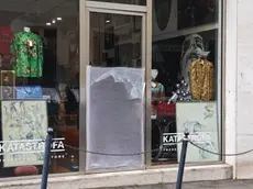 La vetrata danneggiata del negozio in via dell'Annunziata a Trieste (foto Lasorte)