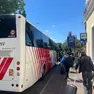 Un bus sostitutivo fuori dalla stazione di Cervignano e i viaggiatori in attesa