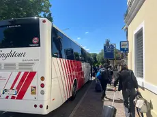 Un bus sostitutivo fuori dalla stazione di Cervignano e i viaggiatori in attesa