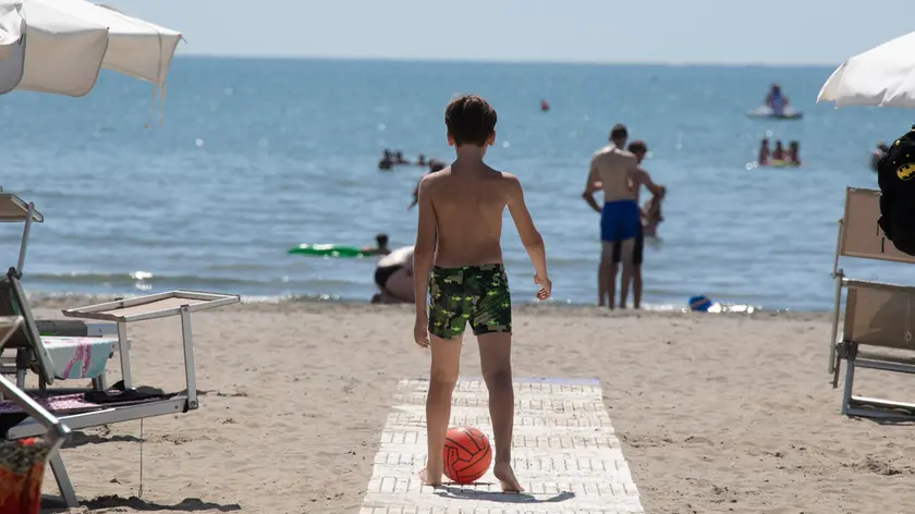 Un bambino con il suo pallone in spiaggia a Grado (foto Katia Bonaventura)