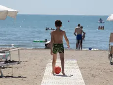 Un bambino con il suo pallone in spiaggia a Grado (foto Katia Bonaventura)