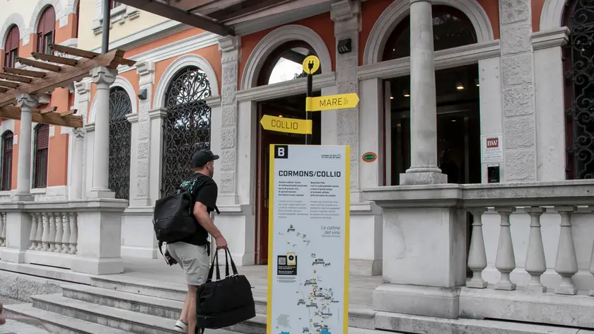 Un ospite con la valigia domenica mentre saliva le scale per entrare nell'Europalace Hotel, che ha sede nell'ex Albergo Impiegati di Monfalcone. Foto Bonaventura