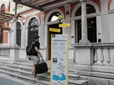Un ospite con la valigia domenica mentre saliva le scale per entrare nell'Europalace Hotel, che ha sede nell'ex Albergo Impiegati di Monfalcone. Foto Bonaventura