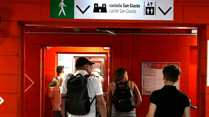 La fila per l'ascensore che porta al castello di San Giusto. Foto Bruni