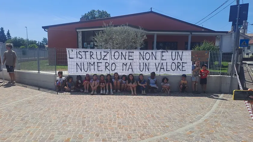 I bambini della scuola e lo striscione con il messaggio di protesta