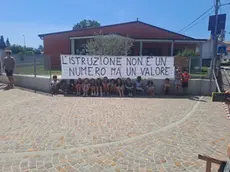 I bambini della scuola e lo striscione con il messaggio di protesta