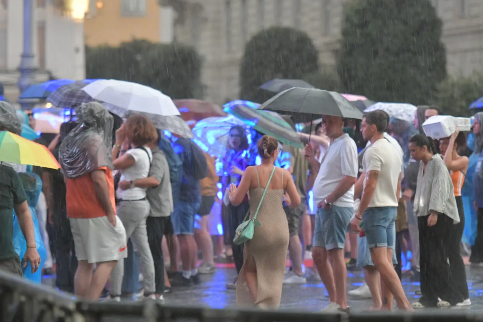 Gli spettatori si riparano sotto gli ombrelli. Foto Bruni