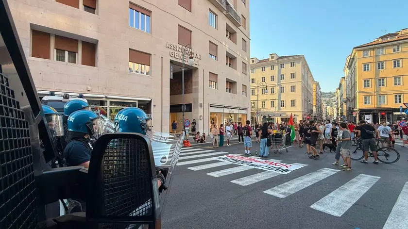 I manifestanti vicino alla Questura blindata dagli agenti anti-sommossa (Silvano)