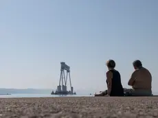 Pierluigi e Ornella guardano la grande gru Goliath che arriva a Monfalcone. Foto Bonaventura