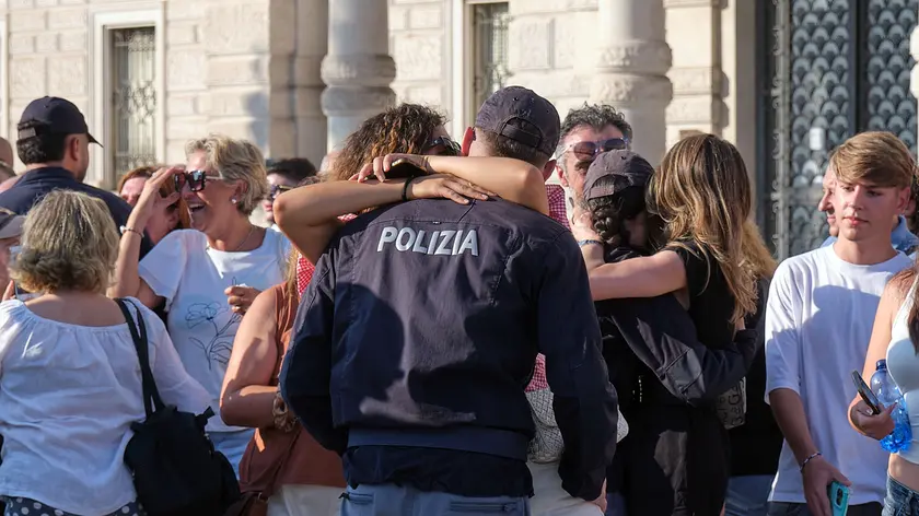 L'abbraccio dei nuovi agenti di Polizia con le famiglie alla fine della cerimonia dell'ammainabandiera. Foto Silvano