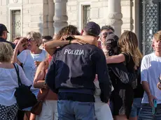 L'abbraccio dei nuovi agenti di Polizia con le famiglie alla fine della cerimonia dell'ammainabandiera. Foto Silvano